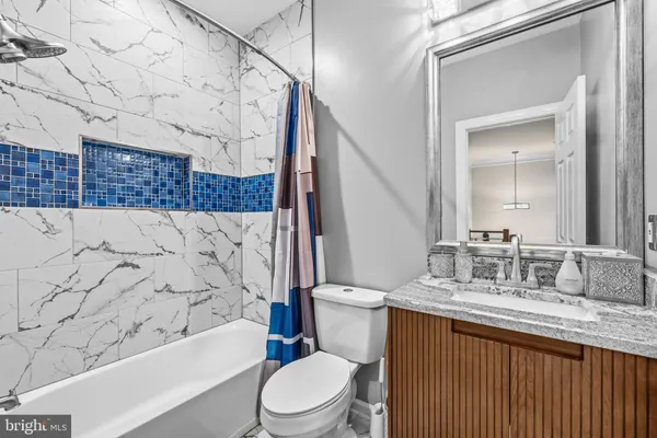 a bathroom with a granite countertop toilet sink and bathtub