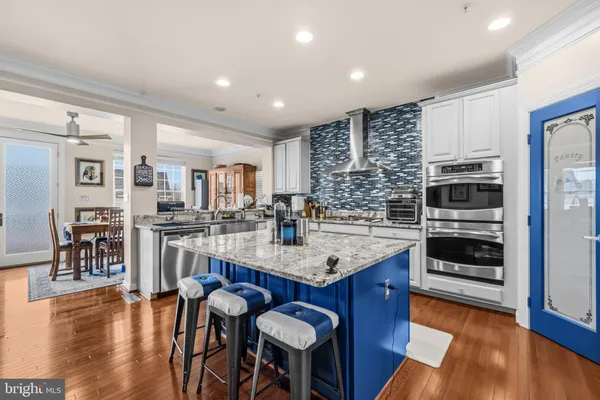 a kitchen with stainless steel appliances granite countertop a kitchen island a stove a table and chairs