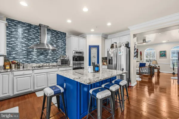 a kitchen with stainless steel appliances granite countertop a stove refrigerator and cabinets