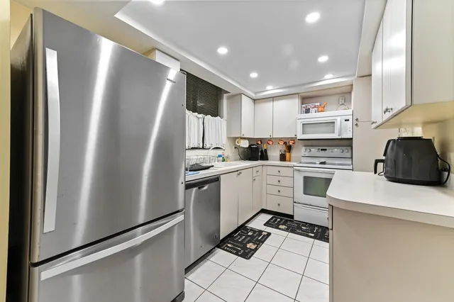 a kitchen with white cabinets and white appliances