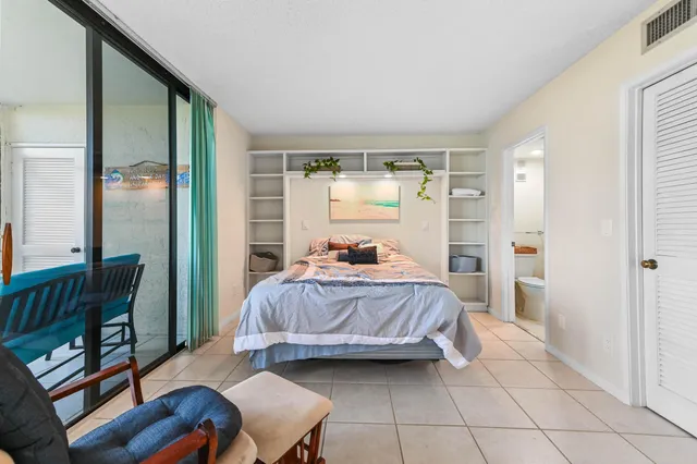 a bedroom with a bed and glass walk in closet