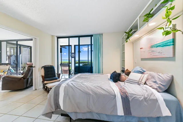 a bedroom with a bed and large windows