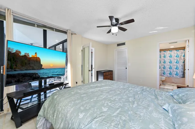 a bedroom with a bed window and flat screen tv