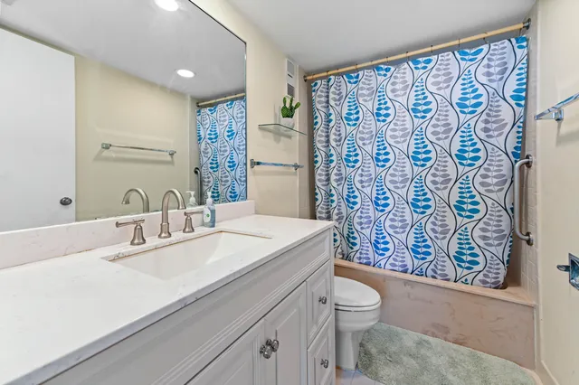 a bathroom with a sink a toilet and shower curtain