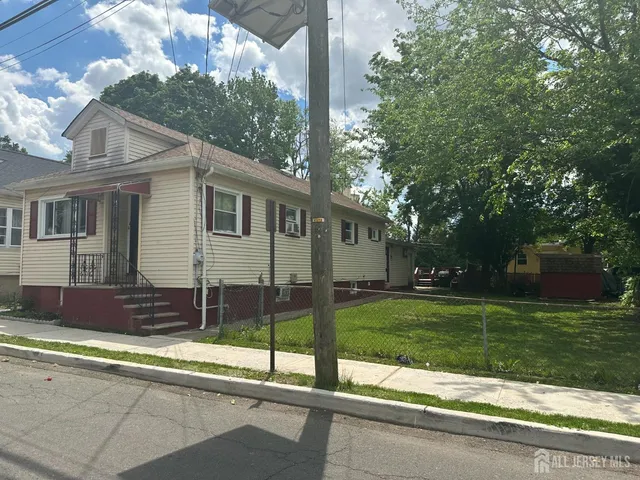 a view of a house with a yard and sitting area