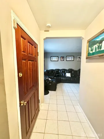 a view of a refrigerator in an empty room and mirror