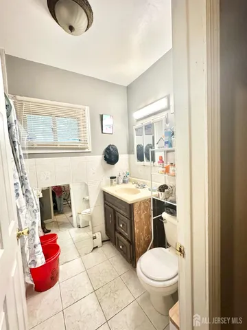 a bathroom with a granite countertop toilet and a sink