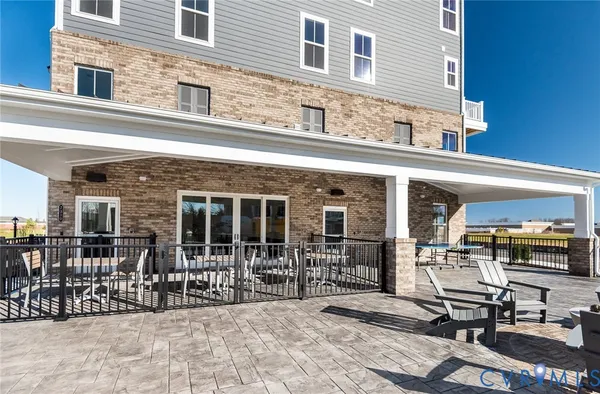 a view of a patio with couches chairs and wooden floor