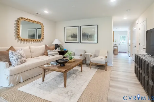a living room with furniture and a wooden floor