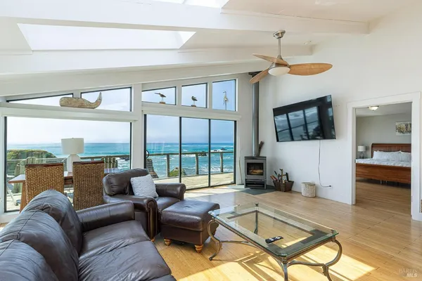 a living room with furniture ceiling fan and a large window