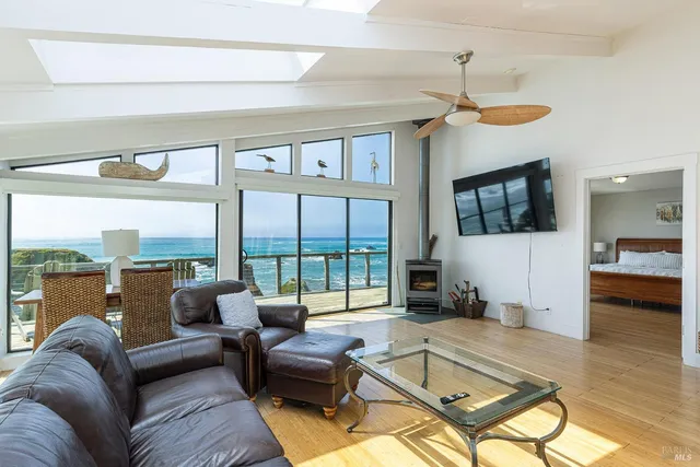 a living room with furniture ceiling fan and a large window