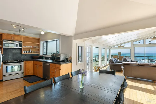a large kitchen with stainless steel appliances granite countertop a large window and a counter space