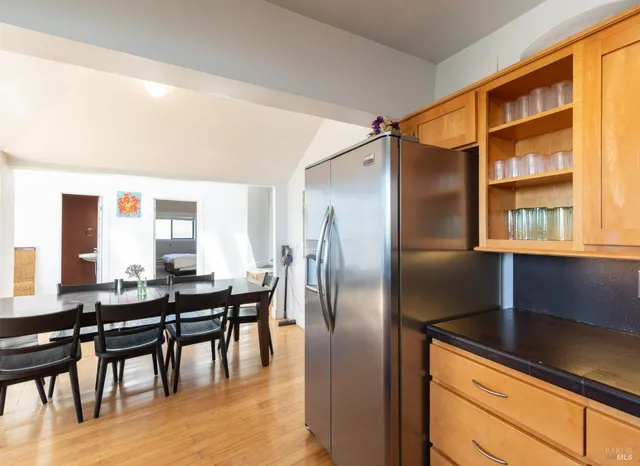 a kitchen with granite countertop a refrigerator and wooden cabinets