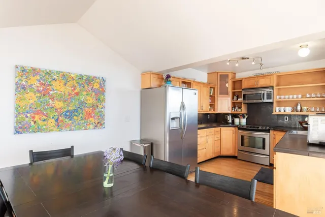 a living room with stainless steel appliances furniture a couch and a view of kitchen