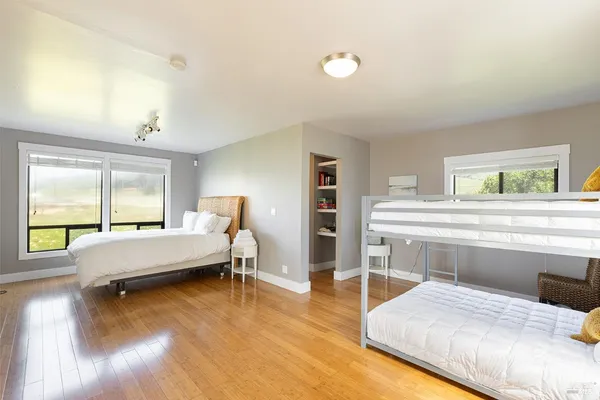 a bedroom with a bed and large windows