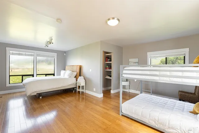 a bedroom with a bed and large windows