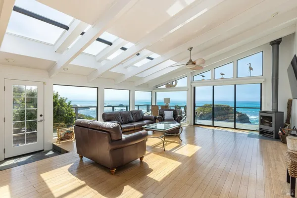 a living room with furniture floor to ceiling window and wooden floor