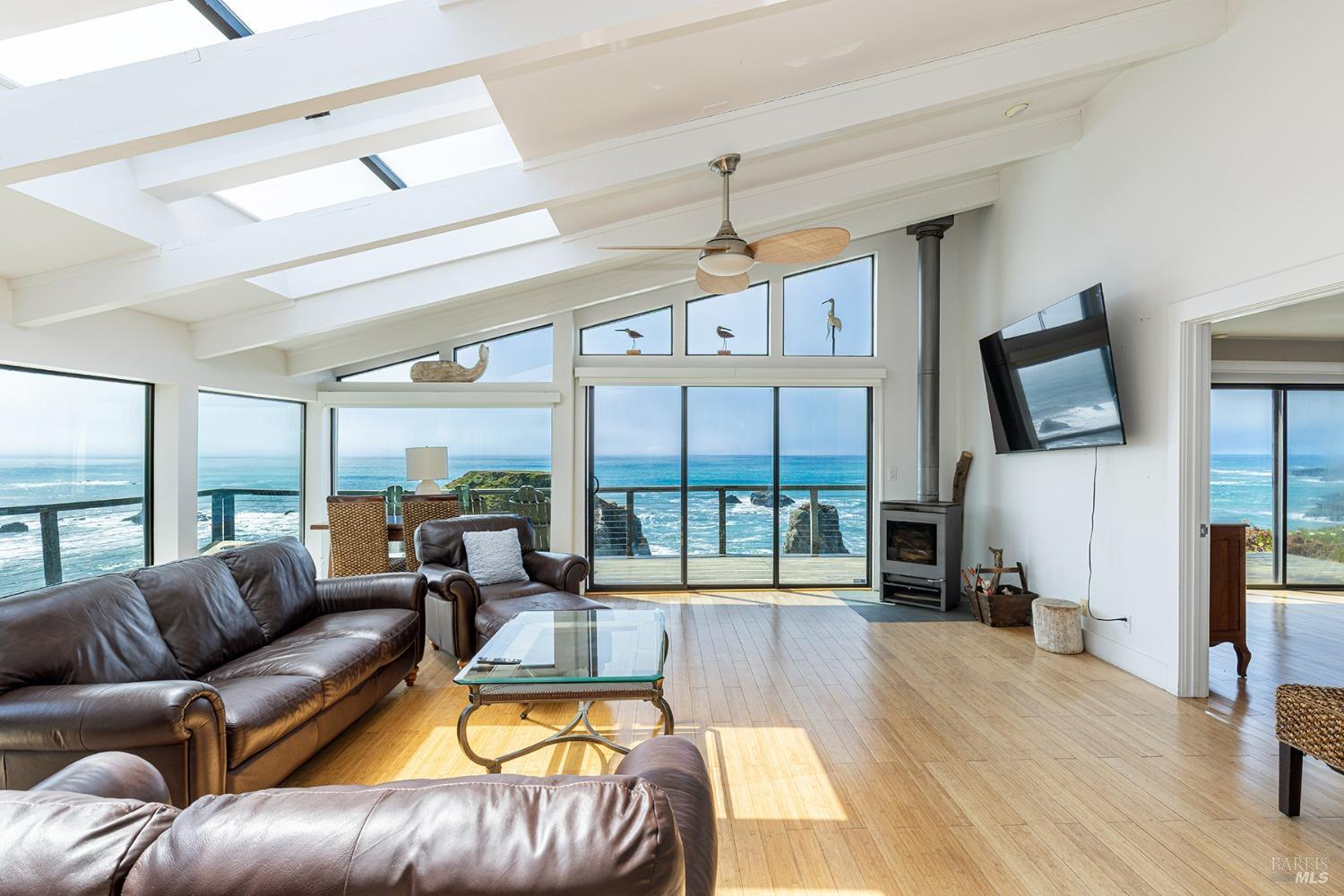6175 Highway 1 Bodega Bay, CA 94923 - Photo 7 of 37 a living room with furniture a flat screen tv and a floor to ceiling window