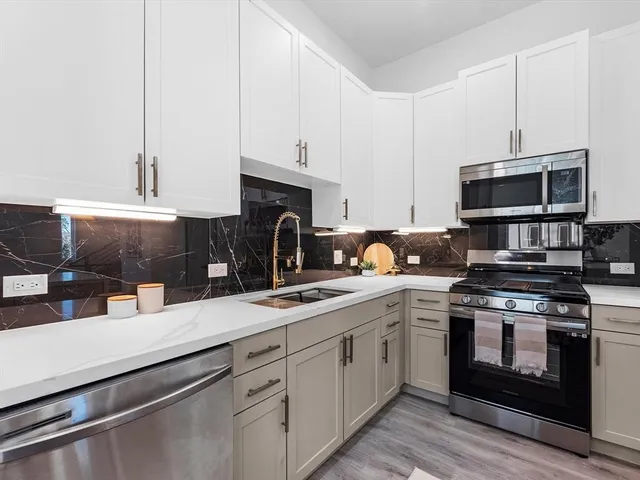 a kitchen with cabinets stainless steel appliances and a sink