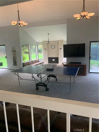 a living room with furniture a chandelier and a flat screen tv
