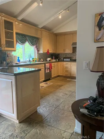a kitchen with stainless steel appliances kitchen island granite countertop a sink and cabinets