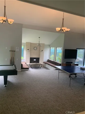 a living room with furniture a chandelier and a flat screen tv