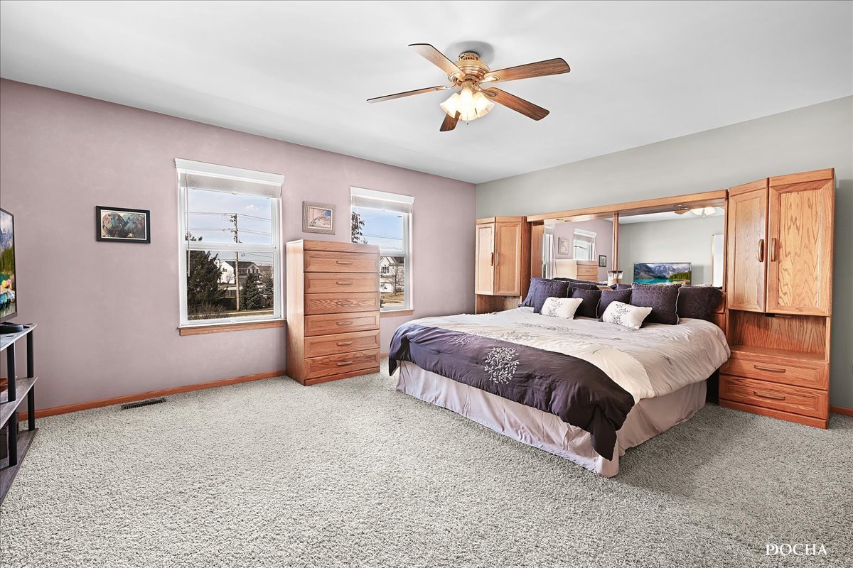 2209 Gray Hawk Drive Plainfield, IL 60586 - Photo 16 of 51 a spacious bedroom with a large bed and a chandelier