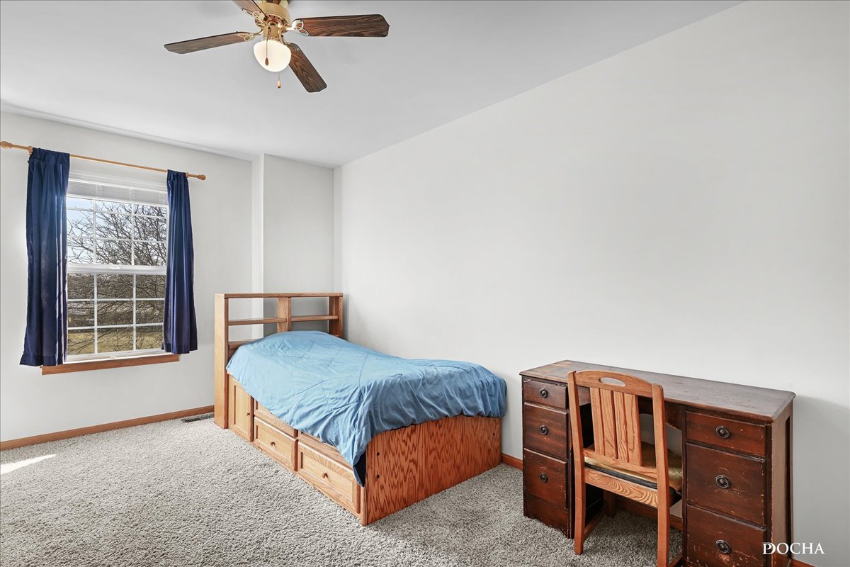 2209 Gray Hawk Drive Plainfield, IL 60586 - Photo 23 of 51 a bedroom with a bed next to a window and a chandelier