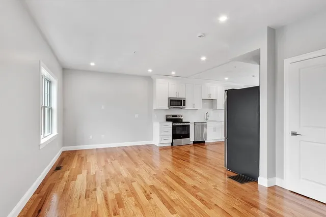 a view of kitchen with stainless steel appliances granite countertop a refrigerator and a stove top oven