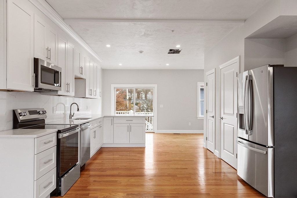 10 Windsor Street, Unit C Worcester, MA 01605 - Photo 4 of 31 a kitchen with stainless steel appliances a refrigerator sink and microwave