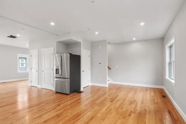 a view of a kitchen with wooden floor and refrigerator