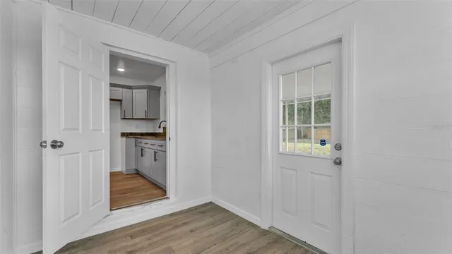 a view of entryway with kitchen and wooden floor