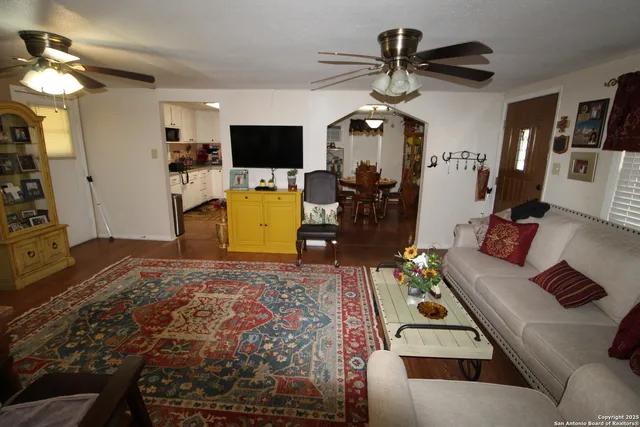 a bedroom with a bed a flat screen tv and a chandelier