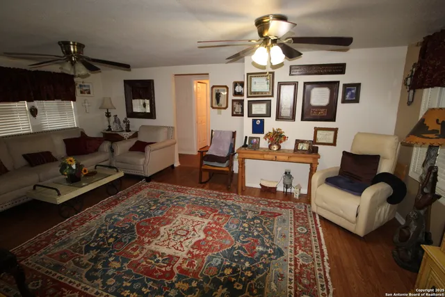 a living room with furniture a chandelier and a rug