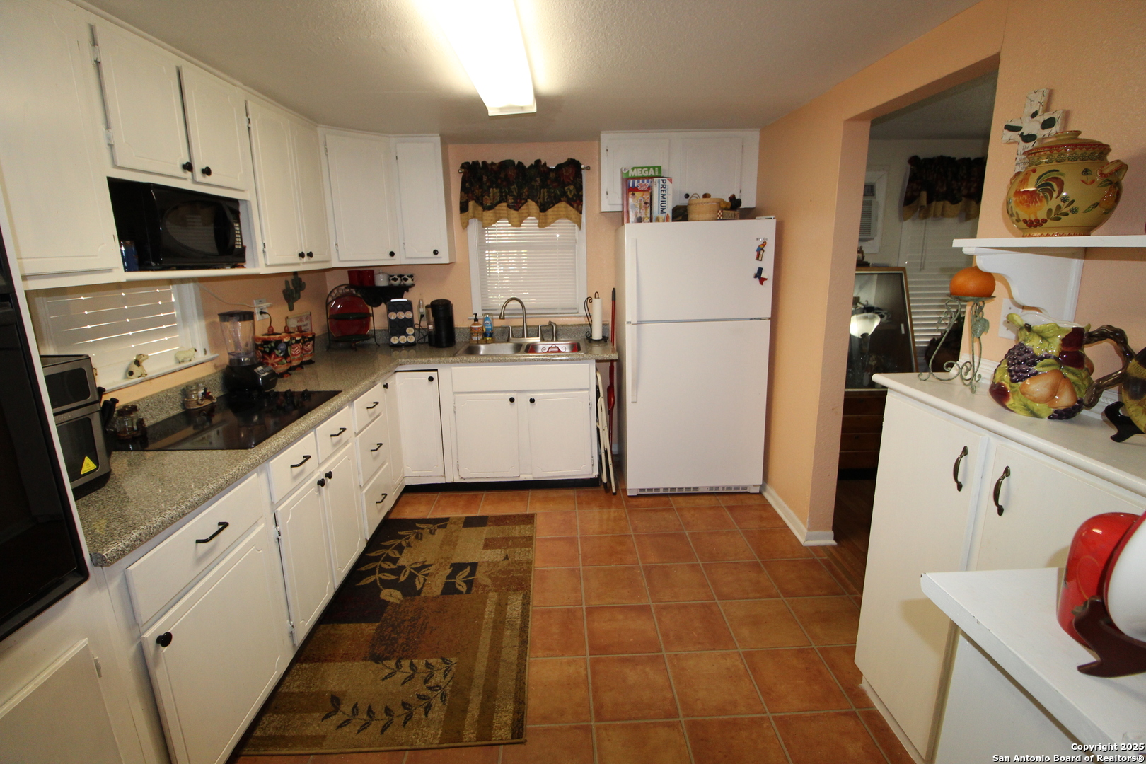 19411 South Somerset Street Lytle, TX 78052 - Photo 14 of 27 a kitchen with a sink a refrigerator and cabinets