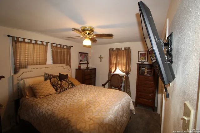 a bedroom with a large bed and a chandelier