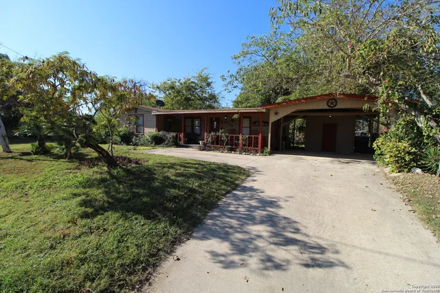 a front view of house with yard and trees