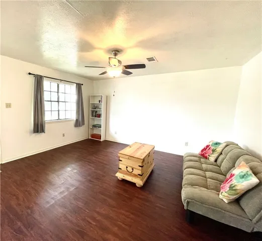 a living room with furniture and a wooden floor