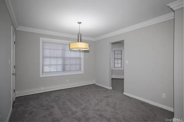 a view of an empty room with a window and fireplace
