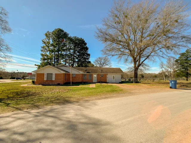 a front view of a house with a yard and trees