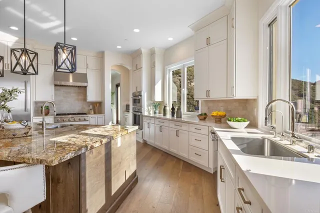a kitchen with stainless steel appliances granite countertop a sink stove and refrigerator