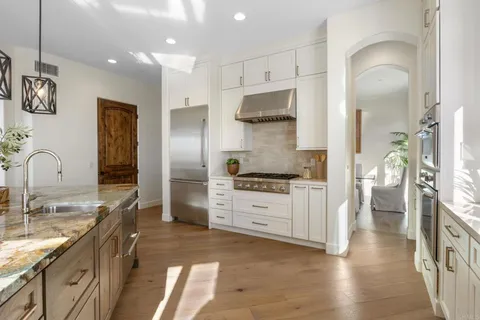 a kitchen with stainless steel appliances granite countertop a refrigerator and a stove