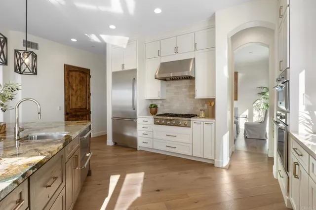 a kitchen with stainless steel appliances granite countertop a refrigerator and a stove