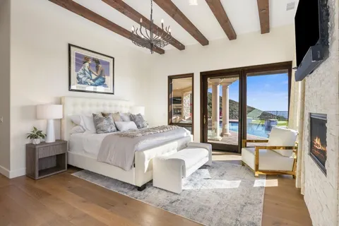 a spacious bedroom with a bed a couch and large window