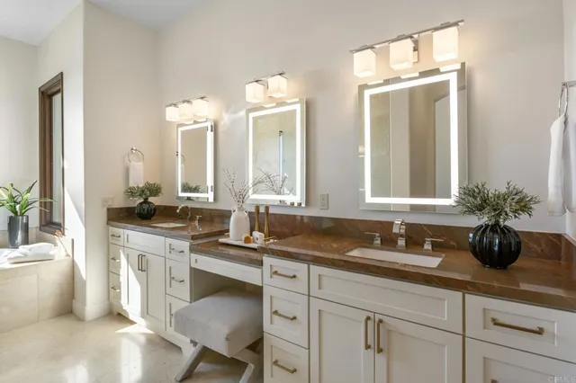 a bathroom with a double vanity sink a mirror and a bathtub