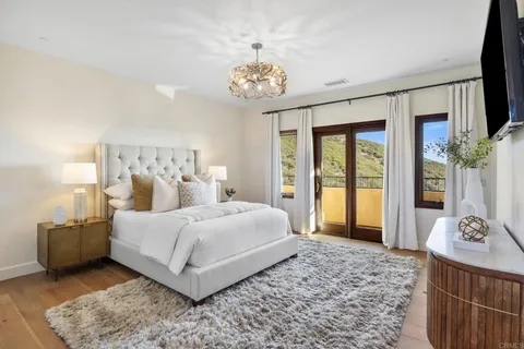 a bedroom with a large bed and a chandelier