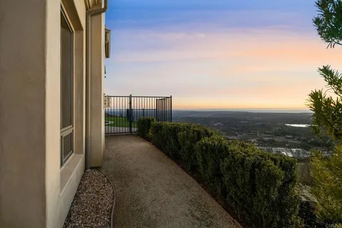 a view of a patio with table and chairs with wooden floor and fence
