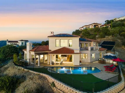 an aerial view of a house with swimming pool and patio