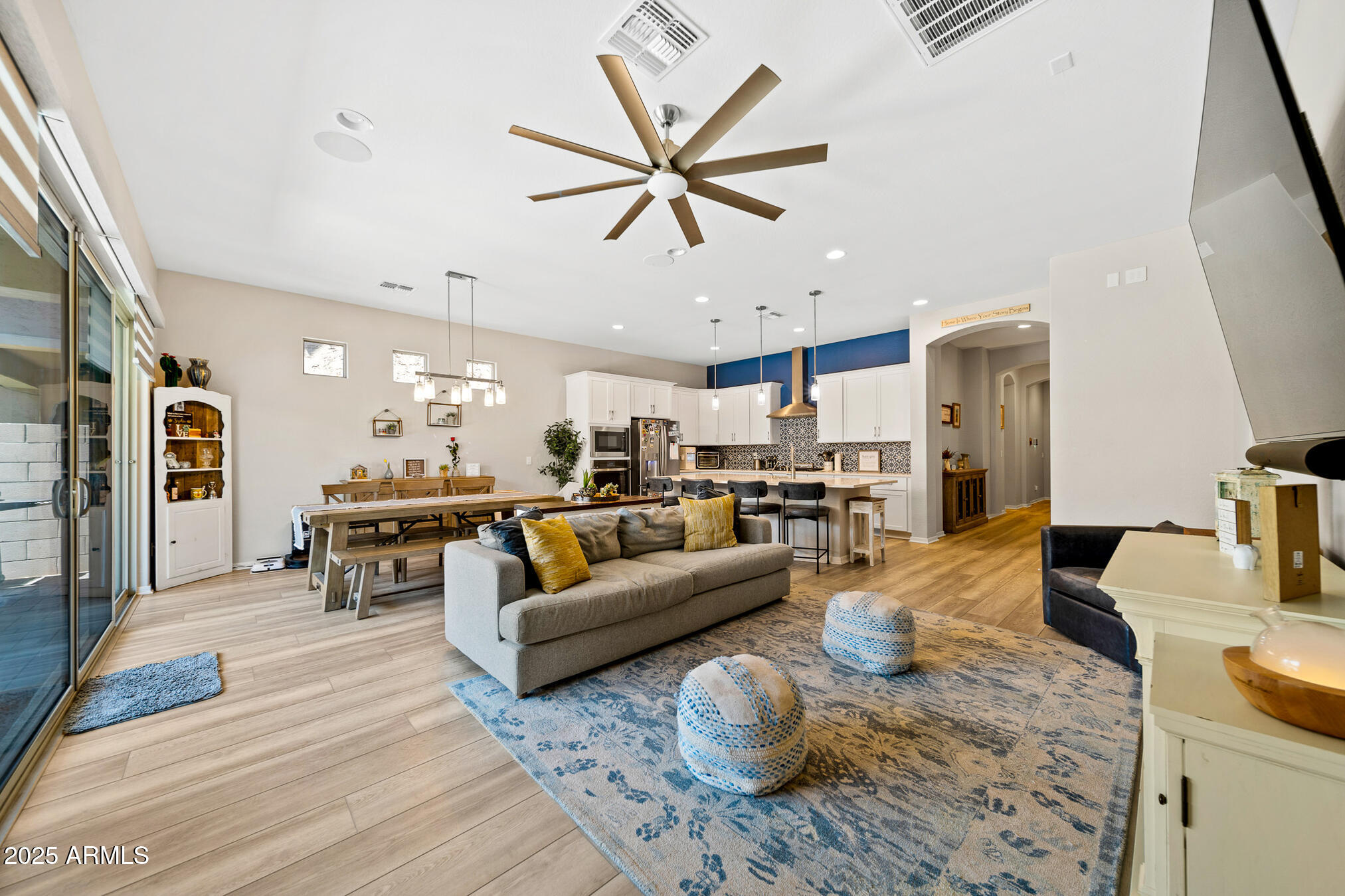 a living room with furniture kitchen view and a chandelier