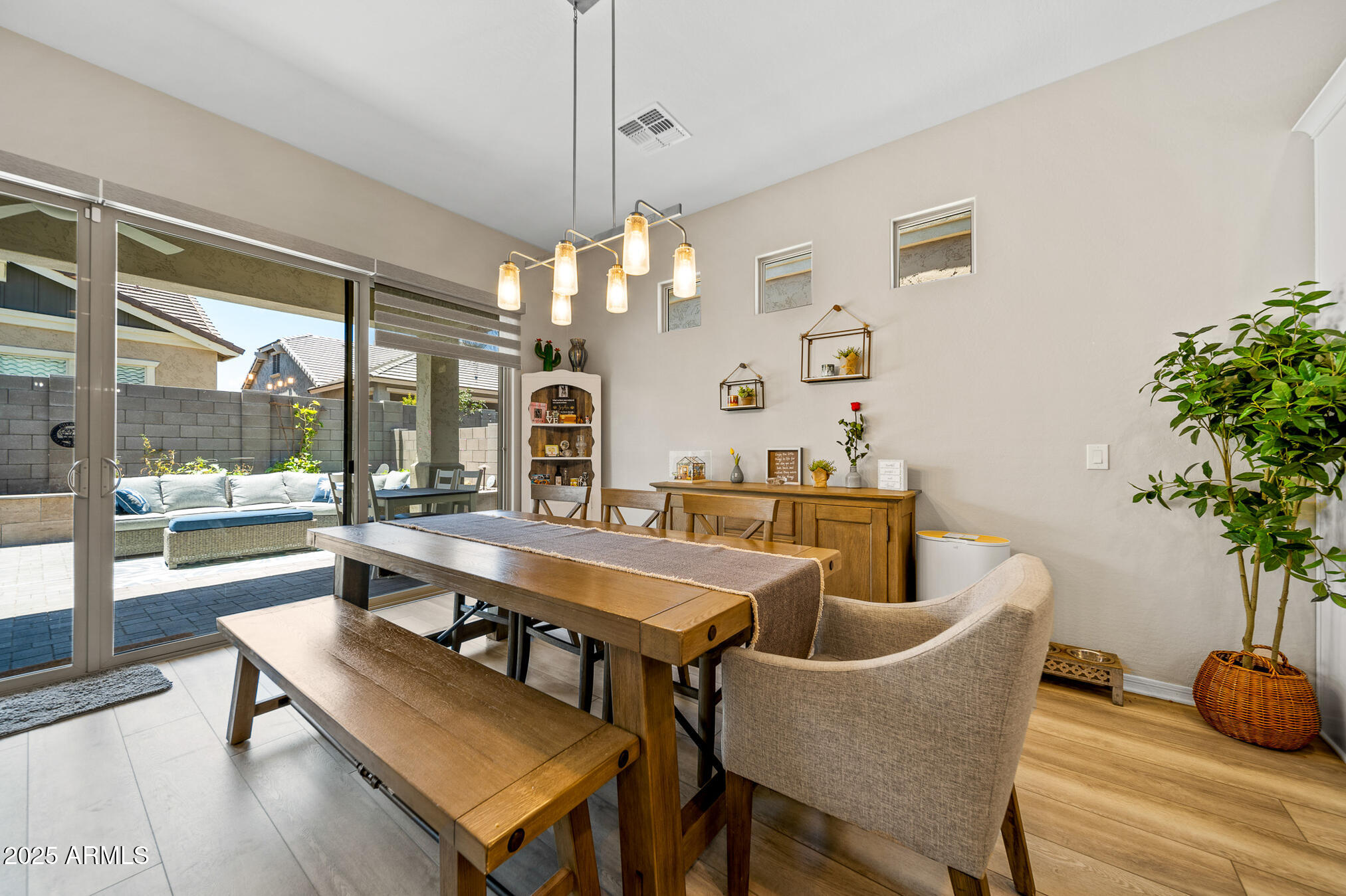 4155 East Jesse Street Gilbert, AZ 85295 - Photo 6 of 71 a dining room with wooden floor a chandelier a wooden table and chairs